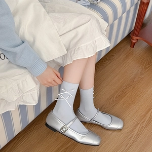Sweet silver Mary Jane shoes with light blue bow socks in a preppy college style look