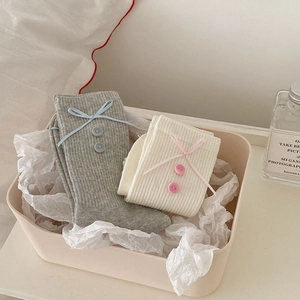 Detail of sweet mid-calf socks with decorative ribbon bows and vintage buttons