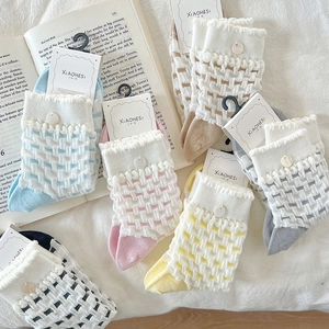 Close-up of knit plaid patterns and button details on colorful women's cotton socks
