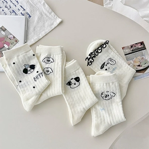 Detail of white crew socks with cute cartoon puppy embroidery and ribbed knit texture