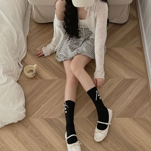 Japanese style black mid-calf socks with white bows and buttons worn with Mary Jane shoes
