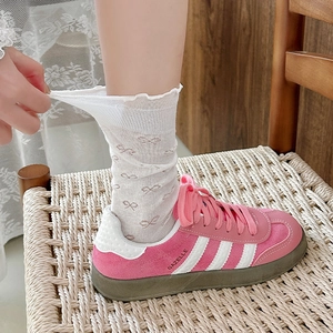 Detailed close-up of breathable mesh socks with lace trim and cute brown bow patterns