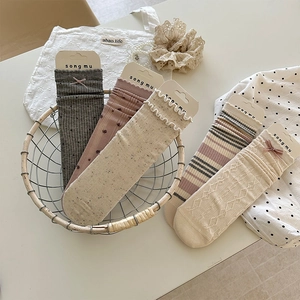 Gros plan de cinq paires de chaussettes en coton avec nœuds et volants, style vintage