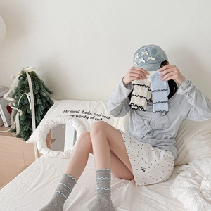 Détail de chaussettes en maille à bords volantés gris blanc bleu avec texture côtelée