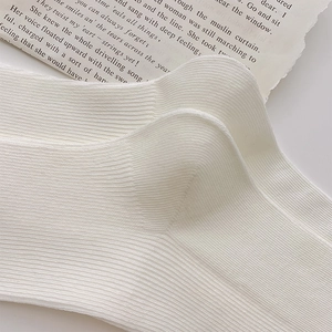 Macro shot of white ribbed knit fabric texture and heel detail of cotton crew socks