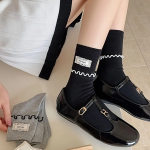 Détail des revers en dentelle à volants et patch KIKI SOX sur chaussettes en coton avec Mary Janes