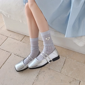 Close-up of lilac ribbed socks featuring a black triangle text label and a stylish cuff