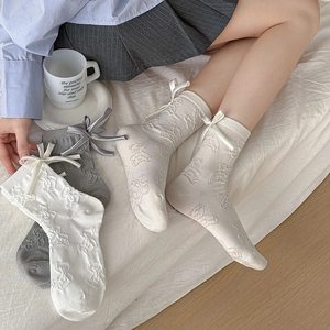 Detail of cream, grey and white socks with 3D bear jacquard and silk ribbons