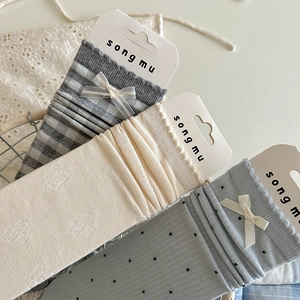 Detailed view of sweet floral and polka dot socks with ribbons in a wire basket