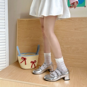 Close-up of silver Mary Jane shoes with triple straps and white lace plaid socks