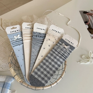 Detailed view of five pairs of cotton socks with dots and floral patterns in a basket