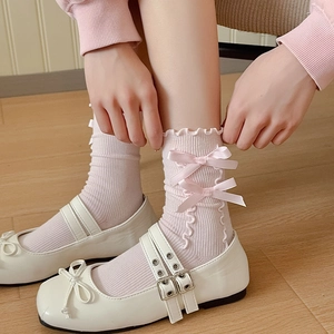 Pink ballet style crew socks with ruffle trim and ribbon bows paired with Mary Janes