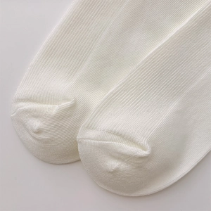 Close-up of white ribbed knit fabric texture on collegiate style heart crew socks