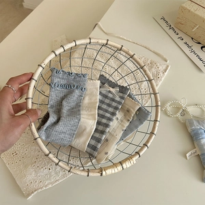 Detail of five cute Korean style socks in a woven basket with lace and pearl accents
