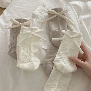 Detail of cream and beige crew socks with 3D bear pattern and satin bow accent