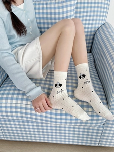 Close-up of white breathable mesh socks with black polka dots and cute cartoon puppy detail