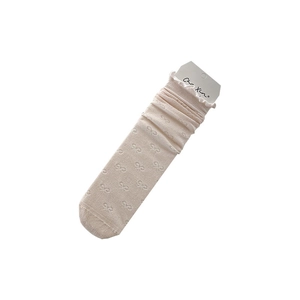 White frilly trim socks with bow patterns and brand card for stylish leather shoes