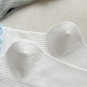 Détail de chaussettes blanches côtelées avec bordure festonnée bleu clair douce