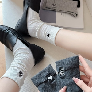 Detail of white and grey ribbed cotton socks with heart and text embroidery patches