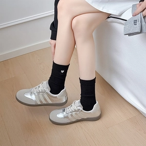 Detail of silver retro sneakers with contrast suede panels and embroidered heart socks