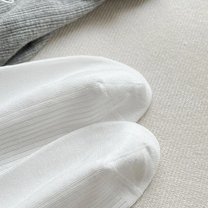 Gros plan sur la maille côtelée blanche et la couture plate des chaussettes ballet