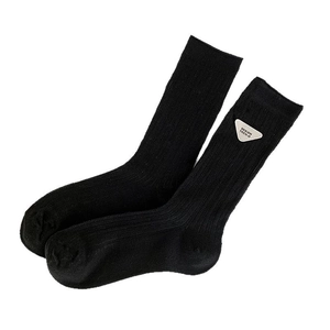 Black ribbed mid-calf socks featuring a trendy white triangle design patch with text