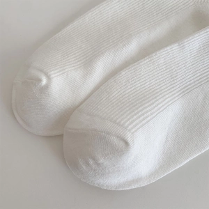 Close-up of white ballet-style ribbed socks with delicate knit texture and toe seams