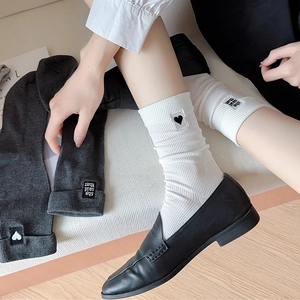 Detail showing ribbed cotton socks with heart embroidery and 'she said that' label