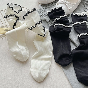 Gros plan de chaussettes en maille côtelée avec bords à volants contrastés noir et blanc