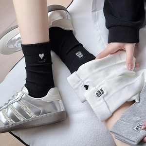 Three pairs of ribbed cotton mid-calf socks with heart embroidery in black, white, and grey