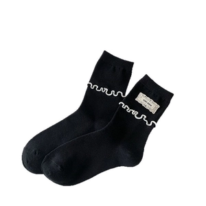 Chaussettes mi-hautes noires en tricot avec bord à volants blancs et écusson KIKI SOX