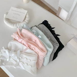 Detail of ballet style ruffle leg warmers with delicate satin bows in multiple colors