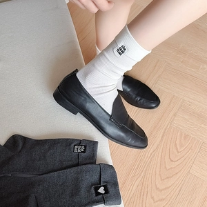 Detail of rib-knit crew socks with heart embroidery and 'she said that' text label