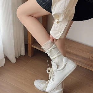 Calze bianche crema con fiocco abbinate a eleganti sneakers in pelle bianca