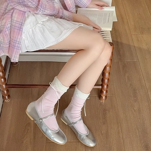 Calze rosa con fiocco abbinate a scarpe Mary Jane argento in un elegante stile crema