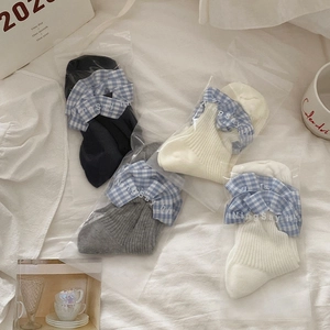 Detail view of cotton socks with blue checkered ruffle trim in black, grey, and white