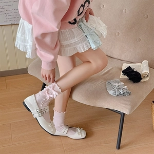 Detail of ruffled lace cuffs and bow accents on ribbed knit socks in assorted pastel colors