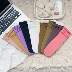 Vue à plat de chaussettes en velours côtelé de dix couleurs sur un tapis tressé