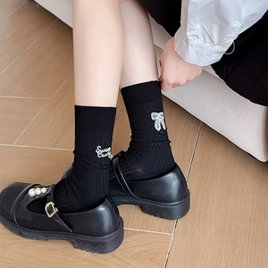 Detail of sweet candy letter embroidery on black ballet style crew socks for women
