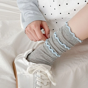 Détail de la maille de chaussettes grises à volants avec bords ondulés bleu clair