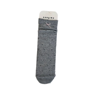Chaussettes grises avec nœuds roses et pois noirs sur un motif en maille côtelée