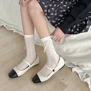 Close-up of cream white hollow out mesh socks with 3D bow and Mary Jane shoes