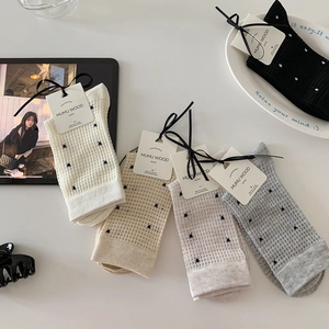 Detail of polka dot mesh mid-calf socks in diverse colors with waffle knit texture