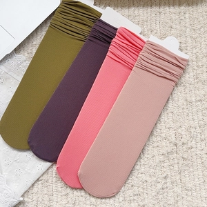 Détail de chaussettes en velours côtelé de couleur verte, violette et nuances de rose