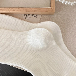 Detail shot of cream white ribbed knit socks with combed cotton blend texture