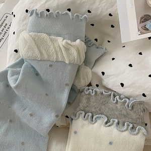 Détail de chaussettes à volants avec bordure en dentelle et motif à pois doux