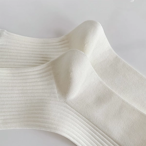 Detailed macro view of white ribbed crew socks with ballet style vertical knit texture