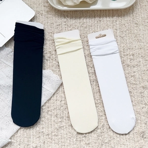 Détail des chaussettes en velours couleur bonbon en noir, beige et blanc à texture côtelée