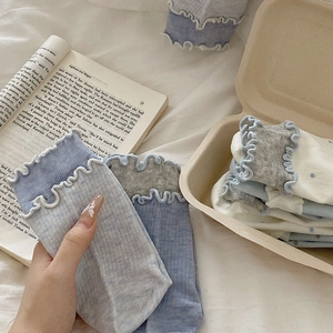 Détail de chaussettes à volants avec pois dans une mise en scène douce et cosy
