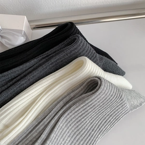 Close-up of four-color ballet style ribbed knit socks with bow embroidery detail